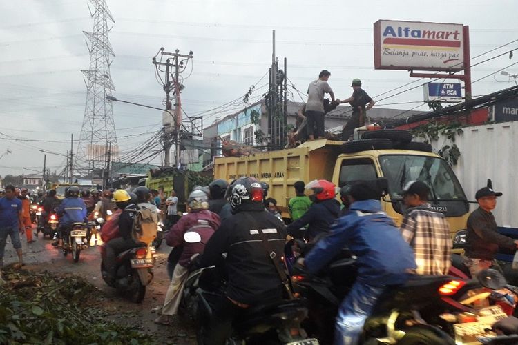 Petugas mengevakuasi pohon tumbang di Jalan Raya Dermaga, Duren Sawit, yang menewaskan satu orang pengendaea, Selasa (2/4/2019).