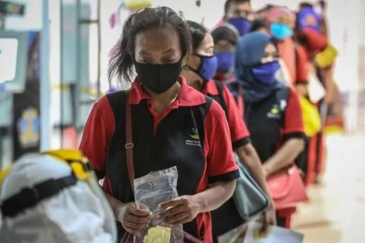 Pekerja migran yang barus saja tiba dari Malaysia terlihat di Pelabuhan Tanjung Priok sebelum masuk ke karantina di Jakarta.