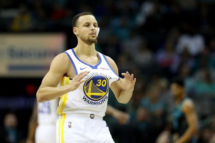 Bintang Golden State Warriors, Stephen Curry, memegang jersey-nya saat laga melawan Charlotte Hornets di Spectrum Center, 25 Februari 2019.