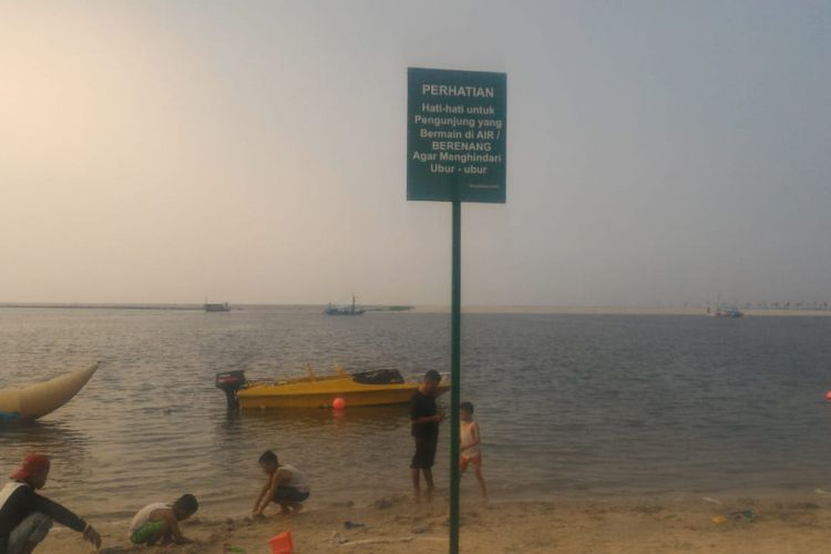 Tanda peringatan menghindari ubur-ubur di Pantai Ancol, Sabtu (20/10/2018)