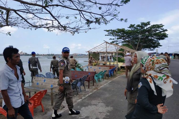 Personel Satuan Polisi Pamong Praja dan Wilayatul Hisbah (Satpol PP dan WH) Kota Lhokseumawe menertibkan pedagang yang berada di sepanjang jalan lingkar obyek wisata Waduk Lhokseumawe, Desa Pusong, Kecamatan Banda Sakti, Kota Lhokseumawe, Aceh, Rabu (27/2/2019).