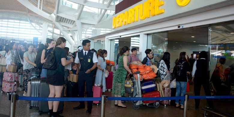Sejumlah penumpang menunggu jadwal penerbangan di Bandara Ngurah Rai, Bali, Jumat (29/6/2018). Berdasarkan hasil rapat evaluasi dampak erupsi Gunung Agung dengan pertimbangan ruang udara bandara bahwa sudah tidak terdapat Sebaran VA dan arah angin cenderung dari arah timur ke barat laut maka Bandara Ngurah Rai mulai dibuka pada Jumat (29/6/2018) pukul 14.30 Wita.  