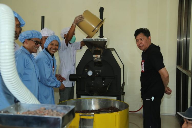 Menteri BUMN Rini Soemarno (seragam biru) didampingi Bupati Banyuwangi Abdullah Azwar Anas saat meninjau langsung proses pengolahan cokelat di Pabrik Pengolahan Cokelat di Glenmore, Banyuwangi, Jawa Timur, Sabtu (16/2/2019).