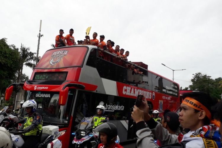 Para pemain Persija Jakarta memamerkan trofi juara pada parade perayaan keberhasilan klub tersebut menjuarai Liga 1 dari kawasan Stadion Utama Gelora Bung Karno menuju Balai Kota, Jakarta, Sabtu (15/12/2018).