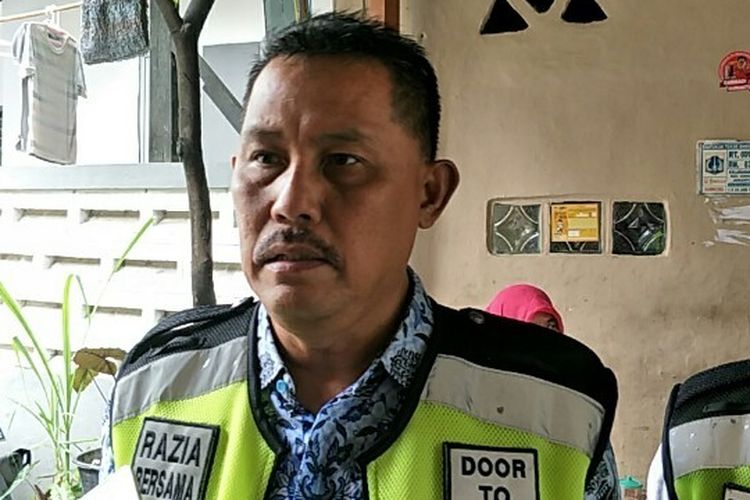 Kepala Unit Pelayanan Pajak Kendaraan Bermotor (PKB) dan Bea Balik Nama Kendaraan Bermotor (BBNKB) Jakarta Barat, Elling Hartono di kediaman penunggak PKB di Jalan Karya Barat IV, Grogol, Jakarta Barat pada Kamis (26/12/2018).