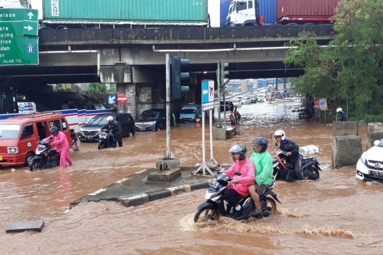 Tampak Banjir setinggi lutut orang dewasa menggenang di kolong Tol JORR Jalan KH.Noer Ali, Bekasi Barat, Kota Bekasi, Senin (26/11/2018).