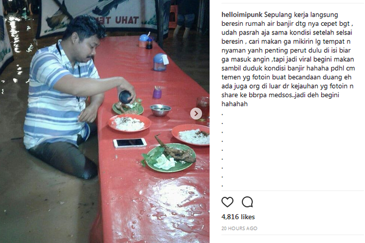 Ipunk makan di tengah banjir di Jatinegara Barat, Jakarta.
