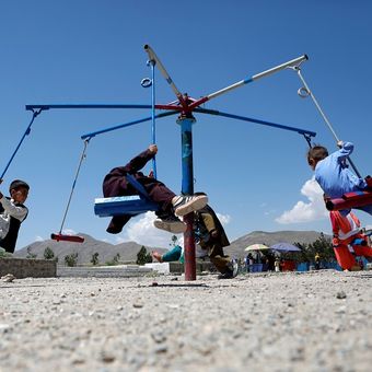 Anak-anak bermain komidi putar pada hari pertama liburan Muslim Idul Fitri, di Kabul, Afghanistan, Selasa (4/6/2019). (REUTERS/Omar Sobhani)