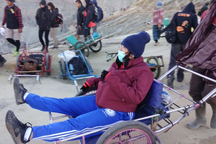 Seorang pengojek atau supir taksi sedang mengantarkan wisatawan turun dari bibir kawah ke kaki Gunung Ijen, Jawa Timur, Sabtu (9/9/2017). Pengojek atau supir taksi tersebut menggunakan gerobak yang telah dimodifikasi.