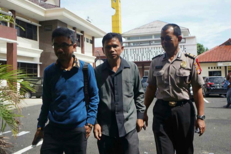 Hitler Nababan (tengah) saat hendak diperiksa terkait kasus ITE di Mapolres Karawang, Kamis (24/5/2018). Ia meminta maaf dan menyesal telah mengunggah meme Amien Rais-Rizieq Shihab.