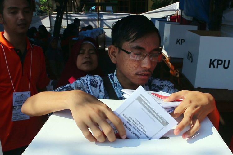 Indra Rukmana (24) penyandang disabilitas tuna netra meraba dan memasukan surat suara ke dalam kotak suara, di TPS 10, Desa Sindang Laut, Kecamatan Lemahabang, Kabupaten Cirebon, Rabu (17/4/2019). Indra menilai persiapan dan pelaksanaan pemilu 2019 masih penuh batas untuk penyandang disabilitas. 