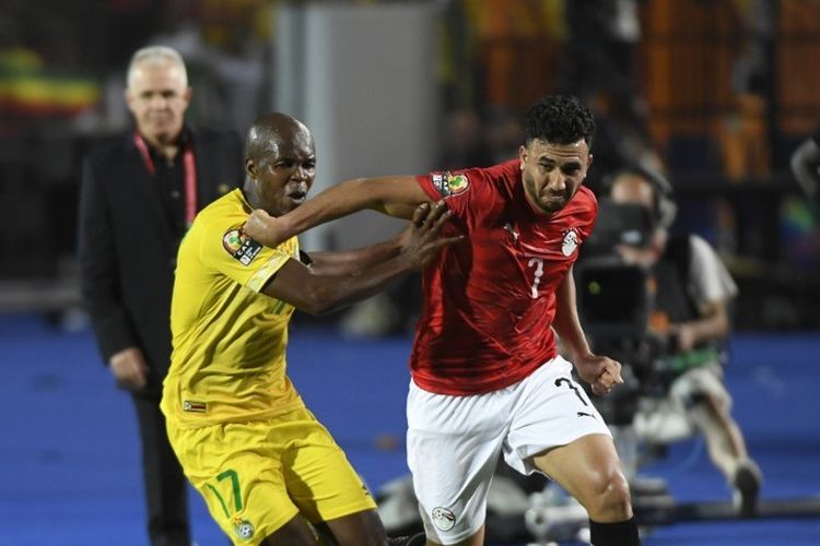Mahmoud Trezegut Hassan mencoba melewati penjagaan lawan pada pertandingan Mesir vs Zimbabwe dalam partai pembuka Piala Afrika 2019 di Kairo, 21 Juni 2019. 