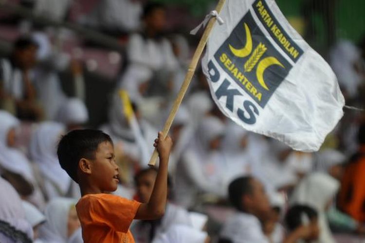 Seorang bocah mengibarkan bendera PKS saat milad Partai Keadilan Sejahtera ke-13, Minggu (17/4/2011), di Stadion Gelora Bung Karno, Jakarta.