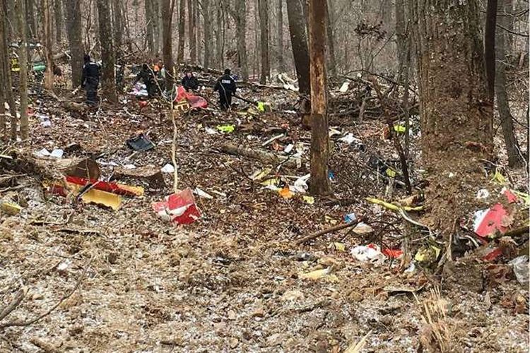 Petugas memeriksa puing-puing helikopter medis yang jatuh di sebuah hutan terpencil di Ohio, Selasa (29/1/2019).