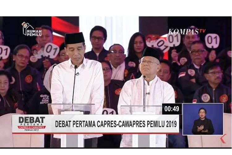 Jokowi melirik catatan kecil dalam debat pilpres 2019.