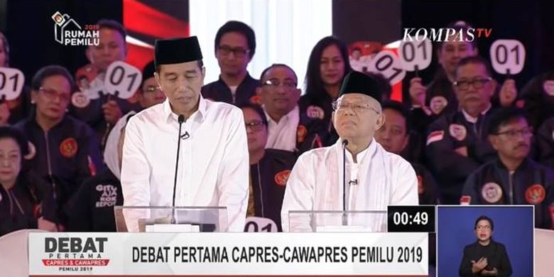 Jokowi melirik catatan kecil dalam debat pilpres 2019.