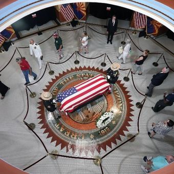 Masyarakat melihat peti mati Senator John McCain saat jenazahnya dibawa ke Arizona State Capitol Rotunda  pada Rabu (29/8/2018) di Phoenix, Arizona. (AFP)