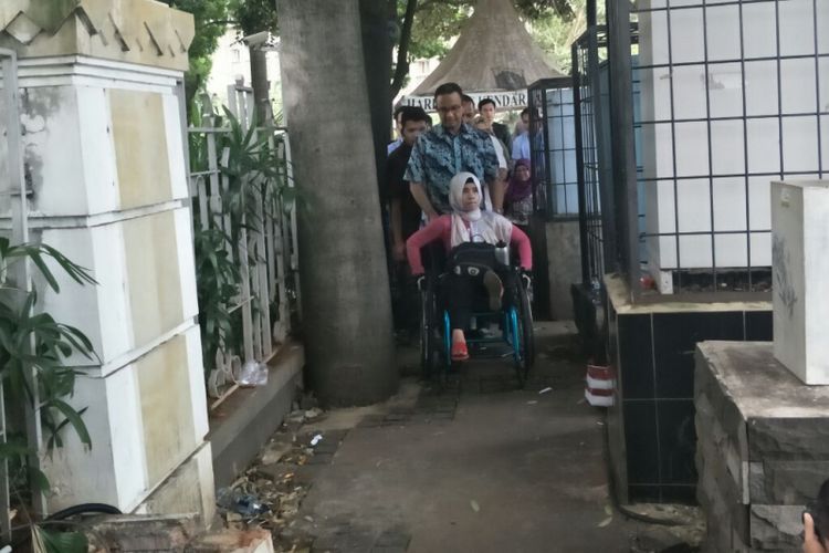 Gubernur DKI Jakarta Anies Baswedan mendorong pengguna kursi roda melintasi Jalan M.H Thamrin, Sabtu (10/3/2018). 