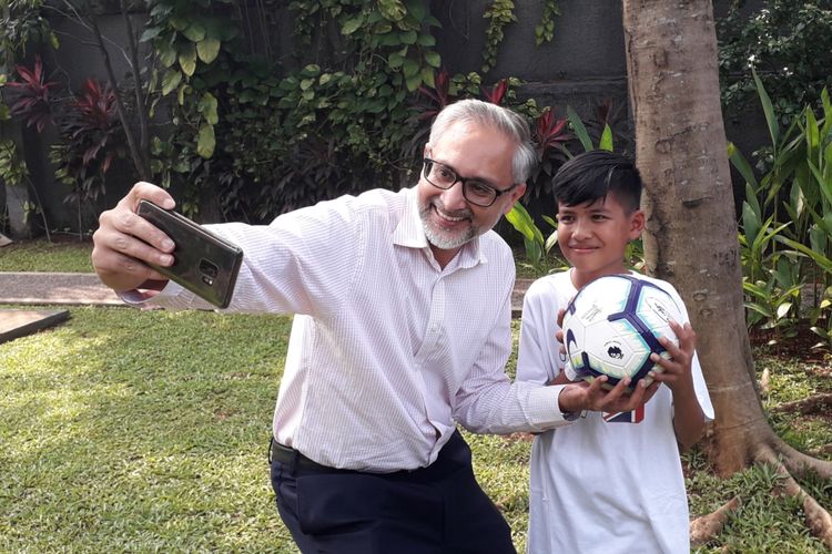 Muhammad Rizky (13), bocah korban Gempa Palu yang diundang ke markas Manchester City, saat bersama dengan Duta Besar Inggris untuk Indonesia, ASEAN dan Timor Leste, Moazzam Malik, di Kedubes Inggris di Jakarta, Kamis (9/5/2019).