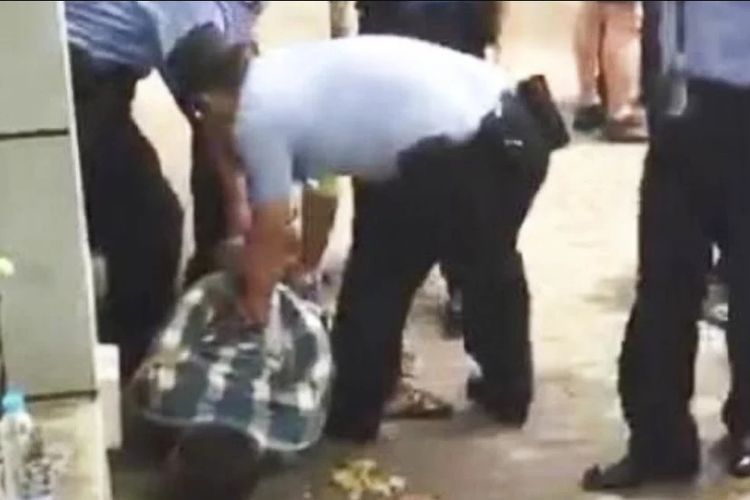 Petugas meringkus seorang pria yang menjadi pelaku penyerangan terhadap siswa di depan sebuah sekolah di Shanghai, Kamis (28/6/2018).