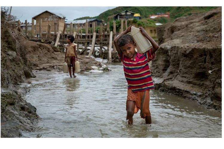 Seorang anak laki-laki berusia 10 tahun dari Myanmar mengumpulkan air di sebuah kamp di Coxs Bazar, Bangladesh. Kekurangan terhadap air dan sanitasi telah menjadi ciri peperangan modern.