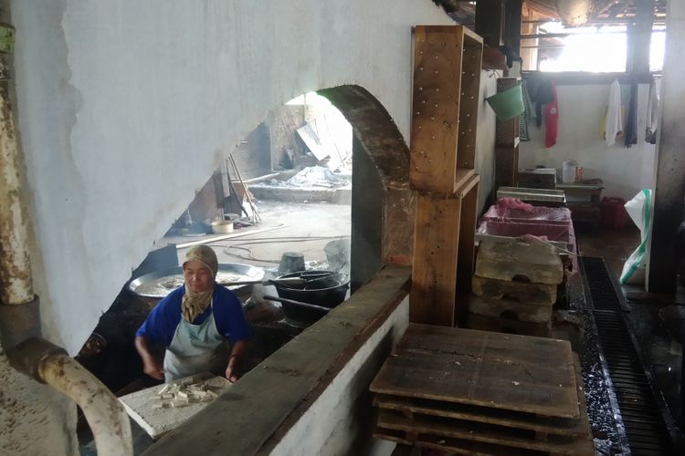 Pekerja pabrik tahu di Dusun Sumbermulyo, Kepek, Wonosari, Gunung Kidul, Yogyakarta sedang membuat tahu. Beberapa hari terakhir ini mereka memperkecil ukuran tahu karena naiknya harga kedelai akibat melemahnya Rupiah terhadap dolar Amerika.