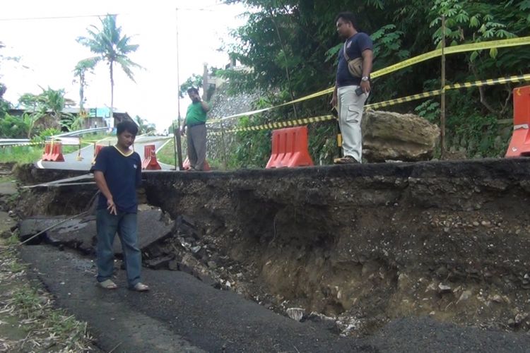 Sejumlah petugas dari balai besar jalan nasional melihat kondisi tanah amblas yang berada di Kilometer 47 desa Cakul kecamatan Dongko Trenggalek Jawa Timur (08/03/2019)