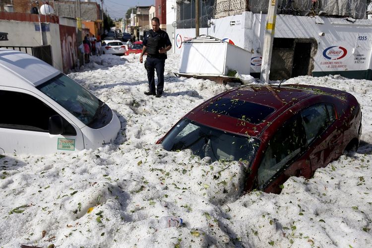 Tumpukan salju setebal lebih dari satu meter menyebabkan kendaraan tertimbun usai badai salju yang menerjang kota Guadalajara, Meksiko, Minggu (30/6/2019).