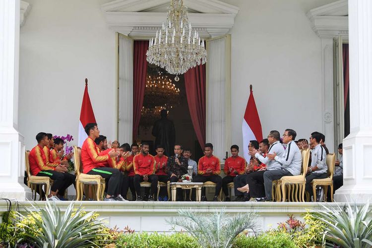 Presiden Joko Widodo (tengah) berbincang dengan pemain Timnas U-22 Indonesia serta ofisial di beranda Istana Merdeka, Jakarta, Kamis (28/2/2019). Presiden memberikan bonus kepada pemain timnas U-22 yang menjadi juara pada kejuaraan AFF U-22 setelah mengalahkan Thailand dengan skor 2-1 dan  berharap Garuda Muda untuk meningkatkan prestasi selanjutnya dengan menjuarai AFC dan Sea Games.