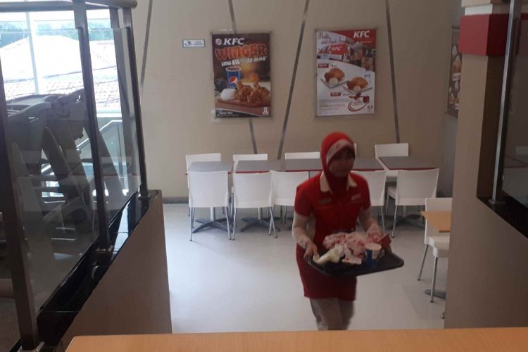 Karyawan KFC masih membantu membersihkan sisa makanan para pengunjung. Foto diambil di KFC Percetakan Negara, Jakarta Pusat, Rabu (23/1/2019).