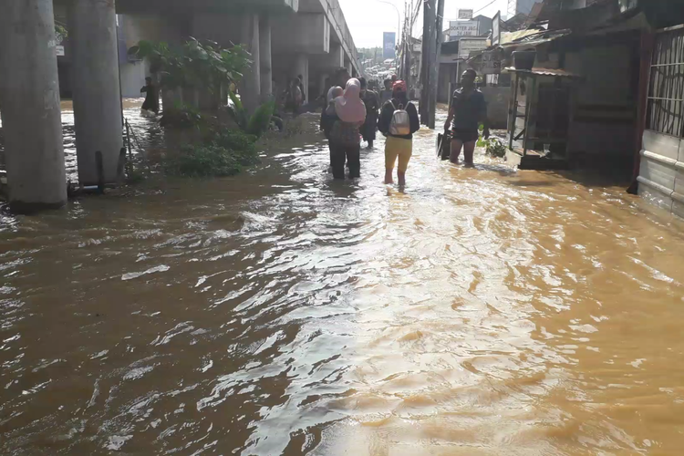Warga terdampak banjir di Cililitan berjalan kaki menuju lokasi pengungsian, Jumat (26/4/2019) pagi.