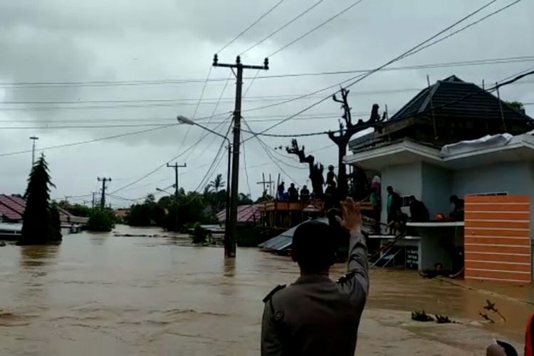 Petugas gabungan di Kabupaten Gowa, Sulawesi Selatan berusaha mengevakuasi warga yang bertahan di atap rumah akibat luapan sungai Jeneberang. Selasa, (22/1/2019).