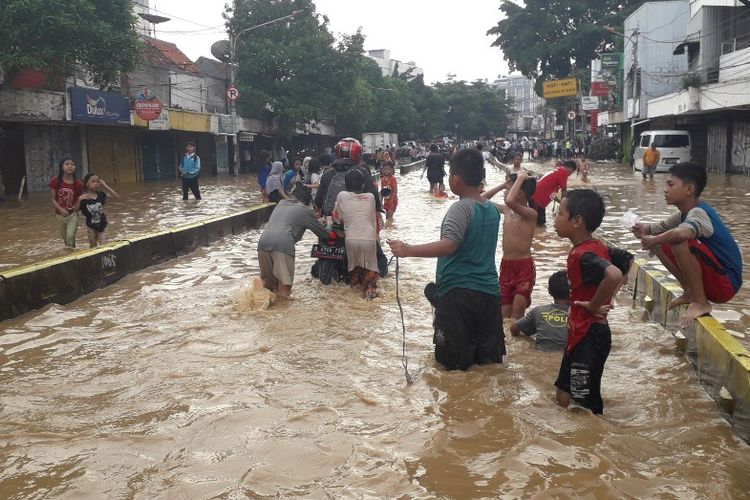 Banjir merendam Jalan Jatinegara Barat Raya di Jakarta Timur akibat luapan Sungai Ciliwung, Jumat (26/4/2019). Dampaknya, sejumlah kendaraan mogok di tengah jalan.