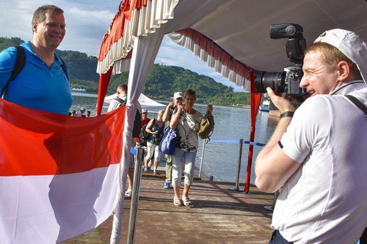 Wisatawan kapal pesiar Aida Vita Cruise berpose dengan Bendera Merah Putih saat tiba di Pelabuhan Lembar, Lombok Barat, NTB, Minggu (3/2/2019). Sebanyak 1170 wisatawan asing asal Jerman melakukan kunjungan wisata ke sejumlah lokasi di Lombok seperti Gili Trawangan, Mandalika, Taman Mayura dan Sekotong sebelum melanjutkan perjalanan ke Pulau Komodo. 