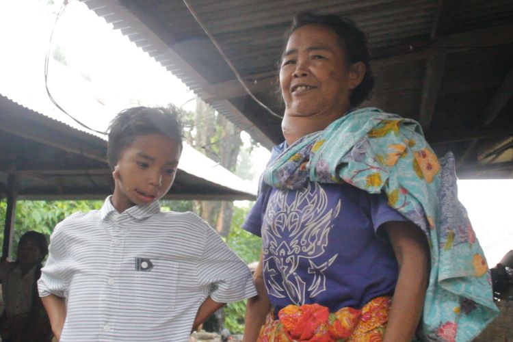Taufik (kiri), bocah disabilitas penyelamat rombongan turis Malaysia yang menjadi korban longsor di air terjun Tie Kelep, Senaru, Lombok Utara, Nusa Tenggara Barat, bersama neneknya.