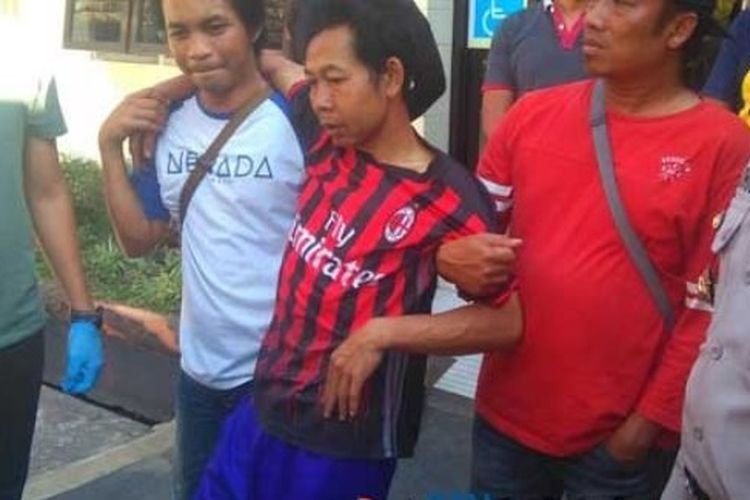 Sobirin (tengah pakai baju klub bola) pelaku penculikan muridnya sendiri saat digiring ke Polres Malang, Sabtu (22/9/2018).