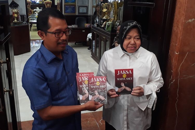 Mantan Adpidsus Kejati Jatim Didik Farkhan Alisyahdi dan Wali Kota Surabaya Tri Rismaharini menunjukkan buku Jaksa Vs Mafia Aset di Balai Kota Surabaya, Selasa (27/8/2019).