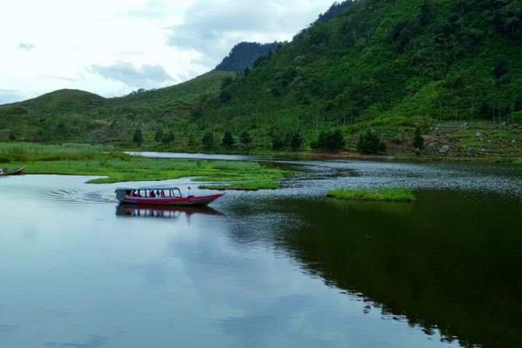 Menelusuri danau dengan perahu yang disewakan warga, menjadi salah satu atraksi wisata di Telaga Danau Rawa Gede, Desa Sirna Jaya, Sukamakmur, Kabupaten Bogor, Jawa Barat.