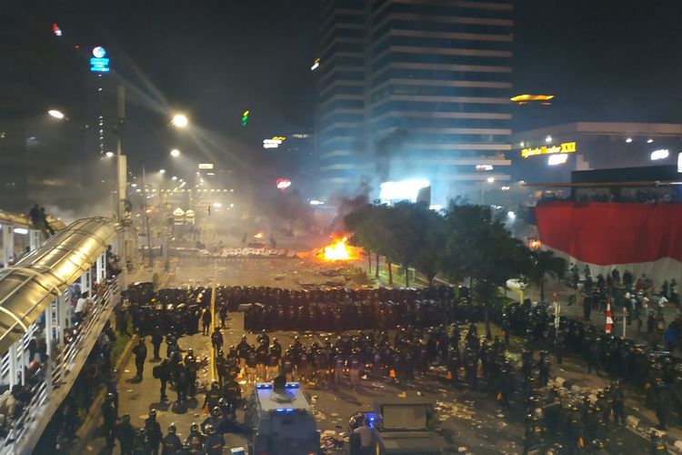 Kondisi unjuk rasa massa di depan Kantor Badan Pengawas Pemilu (Bawaslu) di kawasan Jalan MH Thamrin, Jakarta Pusat, per pukul 21.00 WIB. Gambar diambil dari JPO Sarinah, Rabu (22/5/2019). Polisi memukul mundur massa menggunakan suar (flare) dan gas air mata.