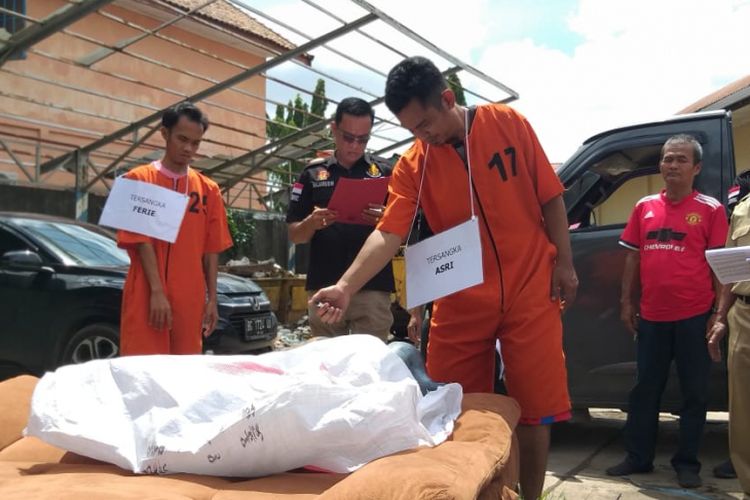  Asri (32) dan Feri (30) saat melakukan rekontruksi pembakaran terhadap jenazah IA yang berlangsung di halaman Mapolda Sumatera Selatan, Senin (28/1/2019).