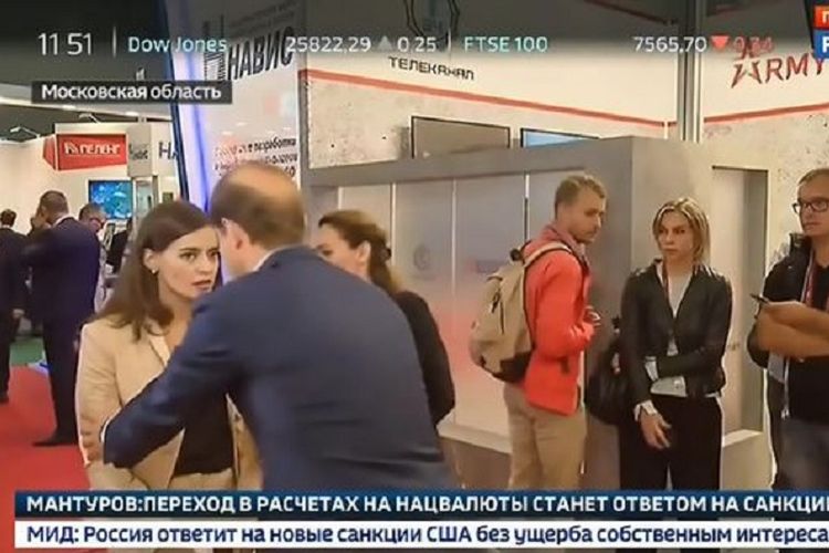 Menteri Perindustrian dan Perdagangan Rusia Denis Manturov (membelakangi kamera) berusaha menolong jurnalis Daria Kozlova yang terhuyung-huyung.