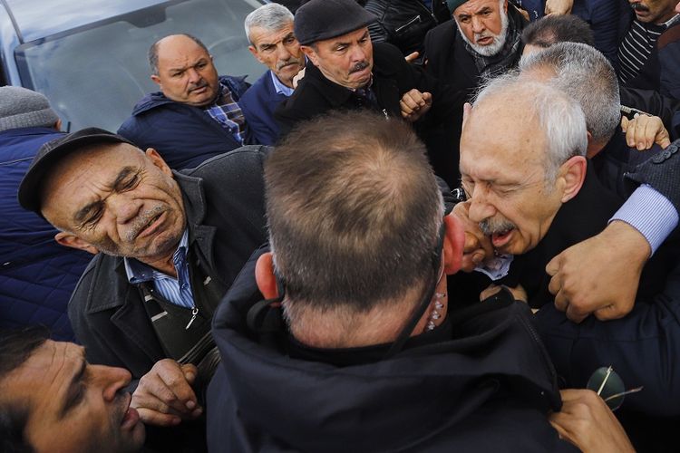 Pemimpin Partai Rakyat Republik (CHP) Kemal Kilicdaroglu (kanan), mendapat pukulan dari massa yang menolak kehadirannya dalam upacara pemakaman para martir di Ankara, Minggu (21/4/2019).