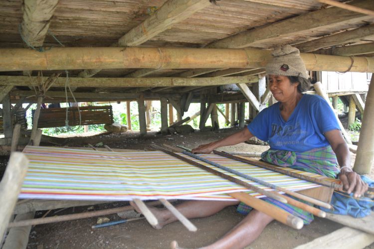 Seorang mama di Kampung Bui, Desa Kaju Wangi, Kecamatan Elar, Kabupaten Manggarai Timur, Flores, NTT, Senin (29/1/2018) sedang menenun kain tenun bermotif Ngada dan Nagekeo. 