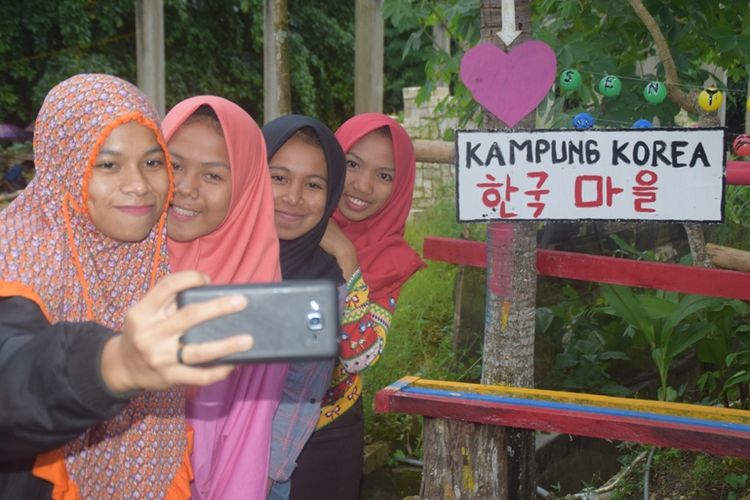 Warga lakukan foto selfie di Kampung Korea yang berada di Kampung Bugi, Kecamatan Sorawolio, Kota Baubau, Sulawesi Tenggara, Senin (28/1/2019).