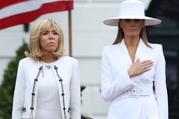 Melania memakai setelan putih saat menyambut kedatangan Presiden Perancis dan sang istri