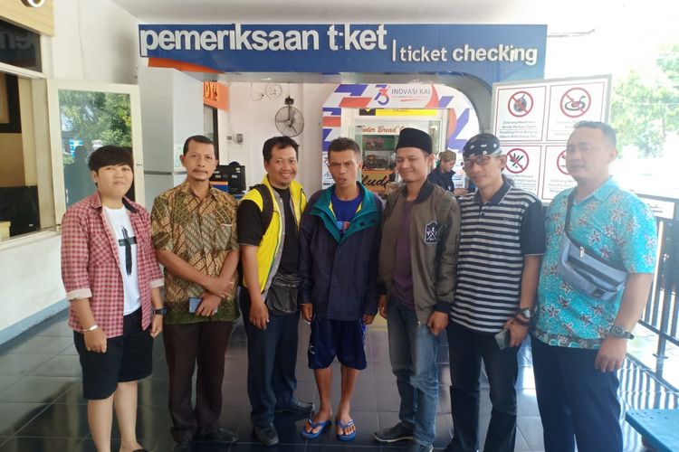 Agus Bustanul Arifin (45) (tengah), warga Garut, Jawa Barat yang ditemukan di Kota Madiun setelah hilang 20 tahun dari kampung halamannya dipulangkan melalui Stasiun Madiun.