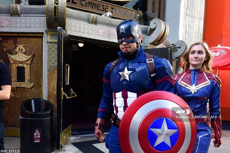 Dua penggemar mengenakan kostum Captain America dan Captain Marvel saat mengikuti lomba kostum menjelang pemutaran Avengers: Endgame di TCL Chinese Theater, Hollywood, California, Kamis (25/4/2019). 