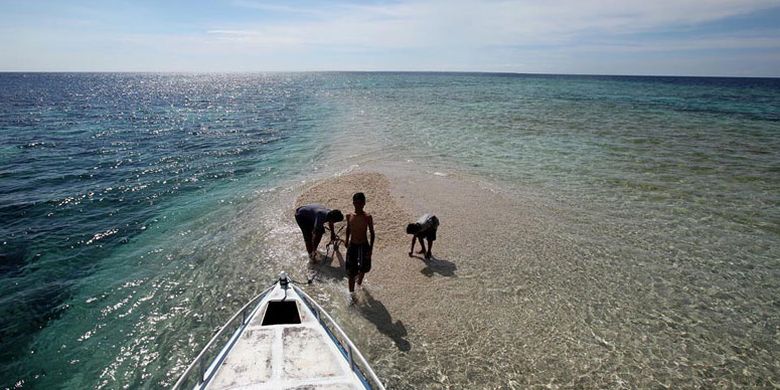 Pengunjung bermain air dan melihat ikan kecil di Takat Sagele, Kawasan Pulau Moyo, Sumbawa Besar, Nusa Tenggara Barat, Selasa (28/3/2017). Selain menjadi surga para penyelam permukaan (snorkeling), Takat Sagele yang merupakan pulau mini dari karang ini juga menarik para wisatawan untuk sekedar berfoto ataupun terun bersandar melihat permukaan dangkal.