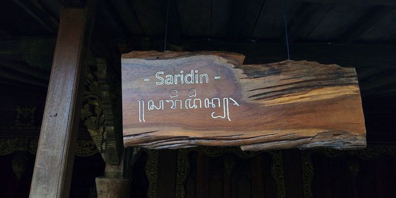 Tulisan penanda nama Rumah Joglo Saridin dalam dua aksara, latin dan aksara Jawa. Rumah Joglo Saridin dahulu merupakan rumah milik Retno Jenoli, kakak dari Sultan Agung Anyokrokusumo, yang menjadi istri Syekh Jangkung (Saridin), tokoh ikonik yang menjadi legenda masyarakat Pantura Timur Pulau Jawa karena kesaktiannya.