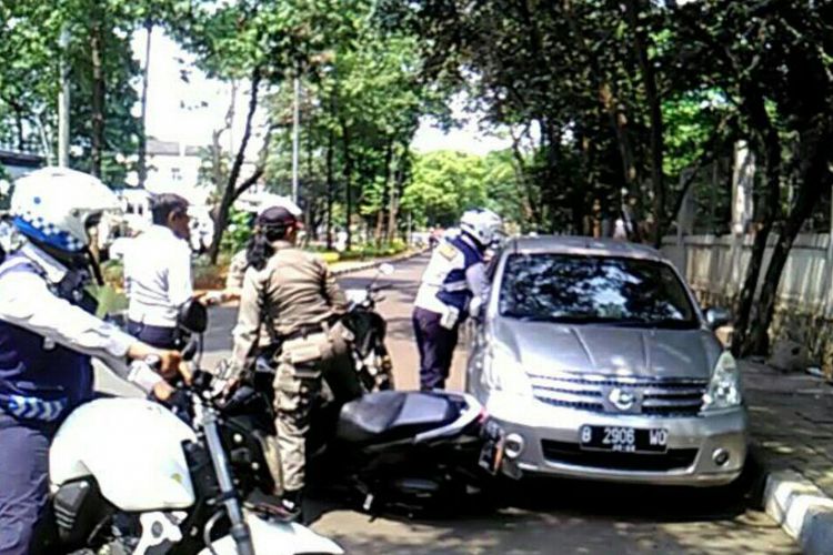 Anggota Satpol PP nyaris ditabrak saat menertibkan mobil yang parkir sembarangan di Jalan Widya Chandra, Jakarta Selatan, Rabu (20/9/2017).